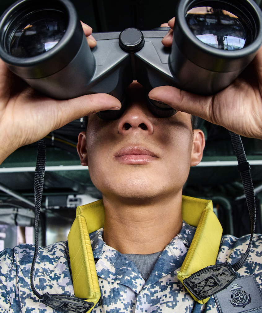 Sailors in camouflage uniforms using binoculars